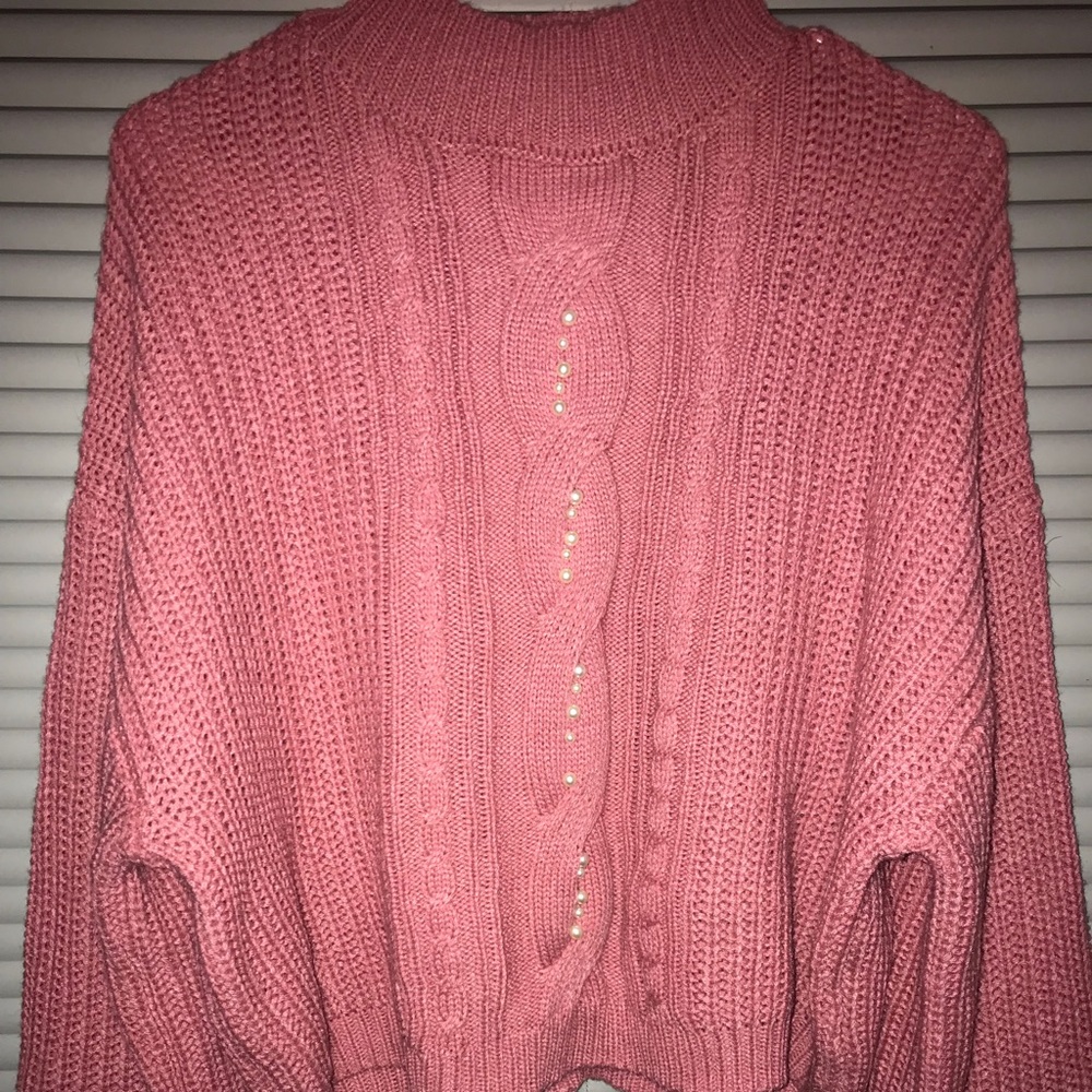 Pink sweater. Pearls in the middle. And never been worn